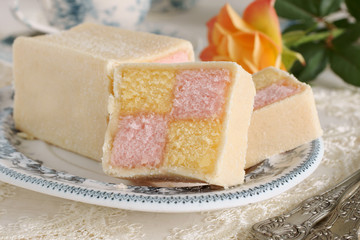 Battenberg Cake or Battenberg Square a sponge cake with pink a yellow checks covered in marzipan