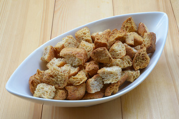 Homemade french croutons in white bowl close up
