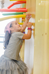 child girl climbing a wall in indoor playarea