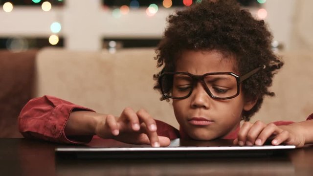 Boy typing on keyboard. Kid in glasses. Ask the internet. Little computer genius.