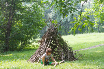 kids playing next to wooden stick house looking like indian hut,