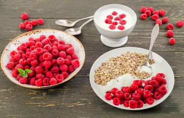 Muesli, yogurt and raspberries on a dark wooden background.