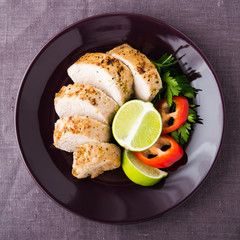 Sliced lime pork tenderloin on dark canvas background top view. Healthy food.
