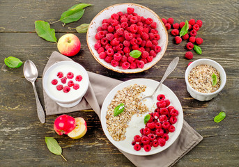 Muesli, yogurt and raspberries on a dark wooden background. Heal