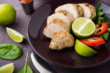 Sliced lime pork tenderloin on dark canvas background close up. Healthy food.