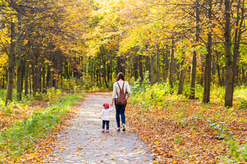 Fototapeta premium Young mother with her little baby girl in the autumn park