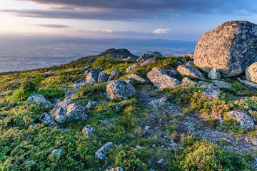Beautiful sunset at Vitosha, Sofia, Bulgaria - jagged rocky terrain with green meadows and steep slopes - popular Bulgarian tourist destination - warm colors, last rays of sunlight