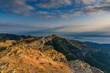 Spectacular view from a mountain top at Thassos island, Greece, popular Greek island - tourist attraction, perfect vacation spot at sunrise - yellow grass in the foreground