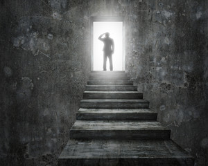 Businessman standing on top of stairs with open door