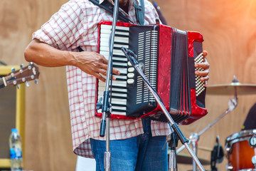 Close up musicians are playing accordion on stage