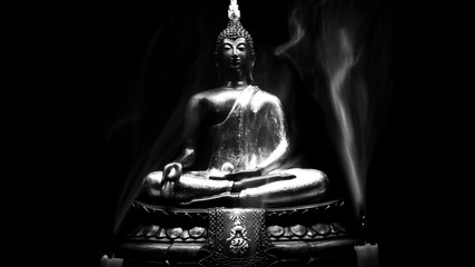 Black and whihte style of Buddha statue and Candle smoke with light dark background . buddha image used as amulets of Buddhism religion.