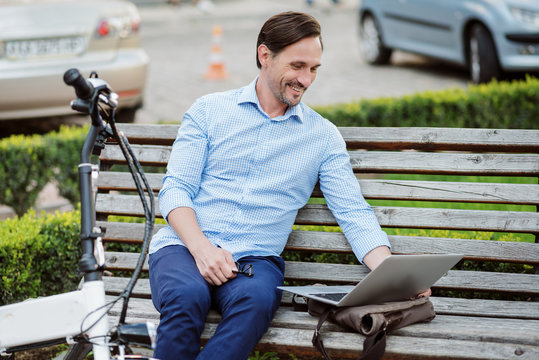 Handsome bespectacled man using laptop.