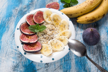 healthy breakfast: oatmeal with fresh figs, bananas,  coconut mi