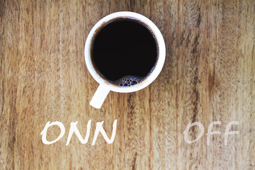 Inscription оnn and off in a cup of coffee and wooden backgroun