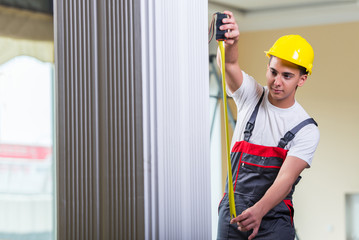 Young repairman with tape measure working on repairs