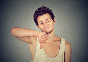 Angry unhappy man showing thumbs down sign in disapproval