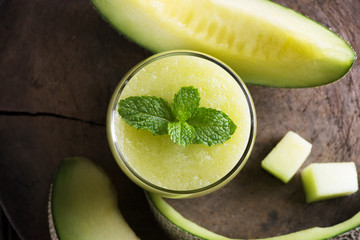 Fresh melon smoothie with almond in a glass on old wooden table background.Selective focus.