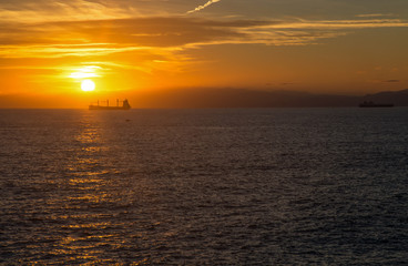 Naklejka na ściany i meble Boat on the horizon at sunset
