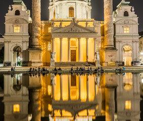Karlskirche or St. Charles's Church - one of famous churches in Vienna, Austria. Beautiful night photography with illumination and reflection in the water. Travel photo of Vienna.