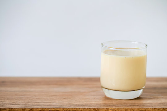 glass of milk on wooden table mock up background.