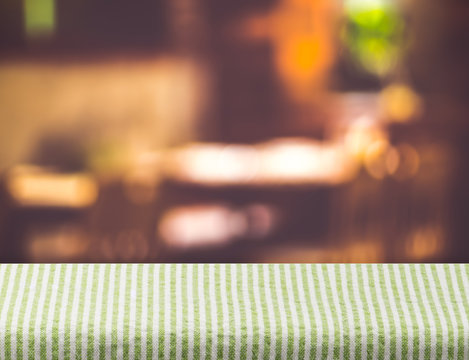 Empty grenn tablecloth on table and blurred restaurant bokeh lig