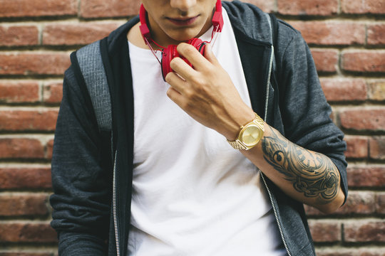 Teenager with a golden clock and tattoo on forearm