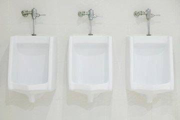 white porcelain urinals in public toilet