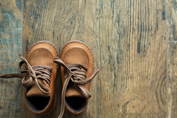 Brown children winter shoes on the wooden background © mariiya