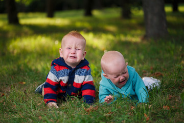 Fototapeta premium two crying children lying in grass