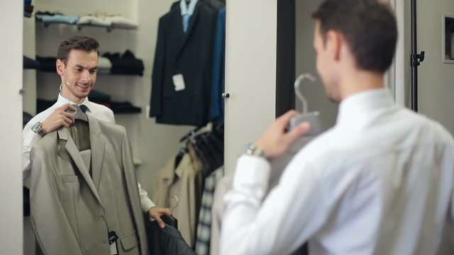 Man choosing a suit at clothing store