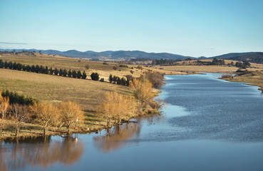 View of river with blue sky and trees during autumn
