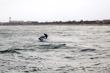 Foto op Canvas guy speeding in the jet ski near the coast © MonikM