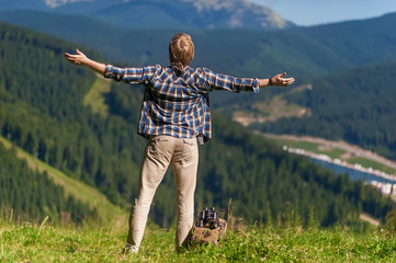 happy man dressed in country style standing on mountain high