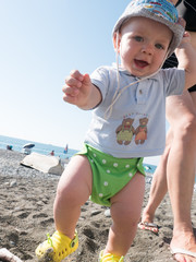 Young mother with her toddler son playing outdoors in city