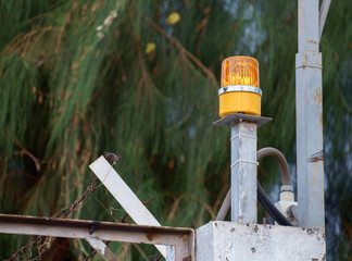 Yellow light signal / View of yellow light signal on fence.