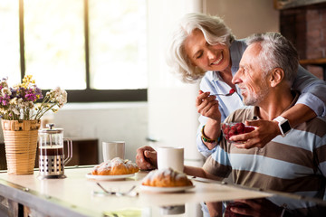 Retired man and woman having breakfast in the kitchen