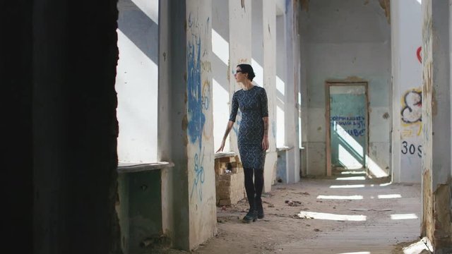 Lonely sad woman in an abandoned house, walking from side to side