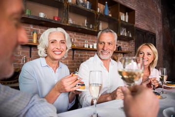 Happy pleasant people talking about wine round the table