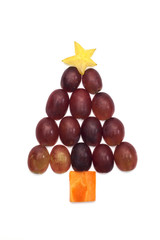 Food art creative concepts. Cute Christmas decoration made of fruits and vegetables over a white background.