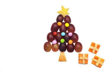 Food art creative concepts. Cute Christmas decoration made of fruits and vegetables over a white background.