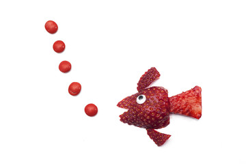 Food art creative concepts. Cute fish made of strawberry over a white background.