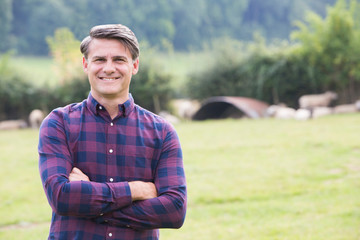 Portrait Of Farmer In Field With Sheep