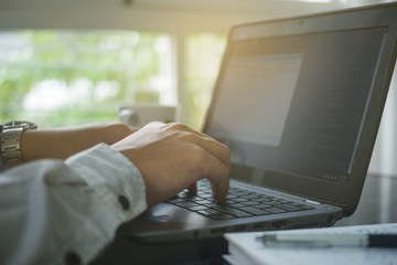 Close up hand type on keyboard laptop in office