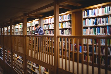 Student reading book in college library