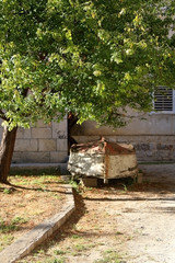 Rusty old boat under a tree. Picturesque garden in Trogir, Croatia.