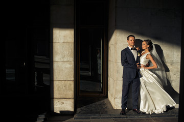 Fototapeta premium The lovely brides embrace near wall