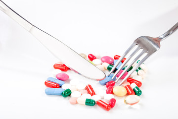 Drugs, medicine in a dish with fork and knife