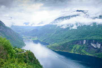 view of the village of Geiranger and rocky shore of Geiranger Fjord