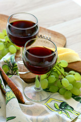 Two glasses of red wine and ripe grapes..