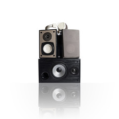 Image of three audio speakers in a wooden case and headphones. Photo isolated on white background with reflection on a horizontal surface. There is an empty seat for your text.
